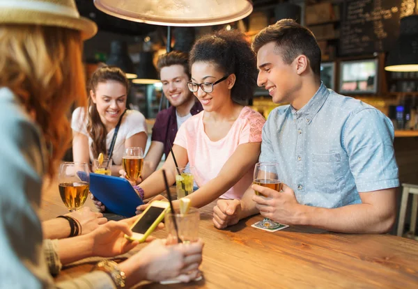 Amis heureux avec tablette pc et boissons au bar — Photo