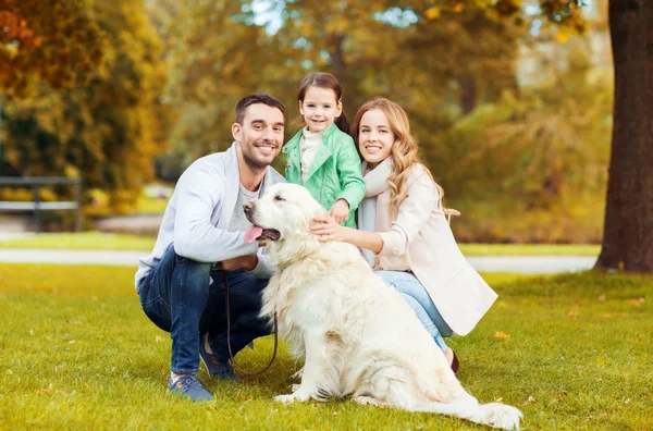 Счастливая семья с лабрадором-ретривером в парке — стоковое фото