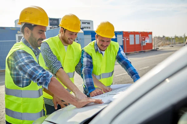 Close up of builders with blueprint on car hood — Stock Photo, Image