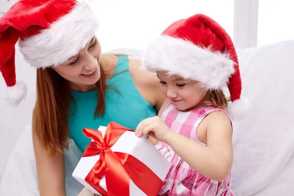 Happy mother and child in santa hats with gift box — Stock Photo, Image