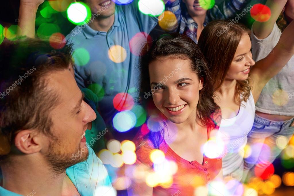 party, technology, nightlife and people concept - smiling friends with  smartphone taking selfie in club. Stock Photo