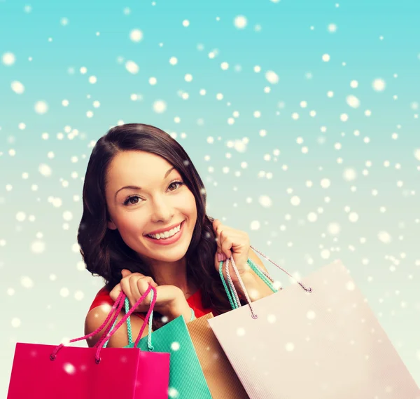 Mujer en vestido rojo con bolsas de compras —  Fotos de Stock