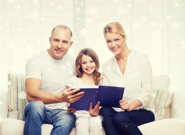 Família feliz com livro em casa — Fotografia de Stock