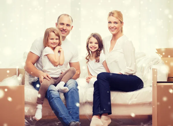 Smiling parents and two little girls at new home — Stock Photo, Image