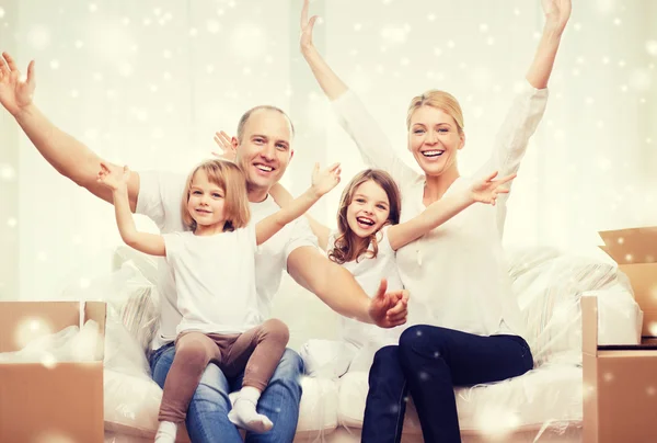 Smiling parents and two little girls at new home — Stock Photo, Image