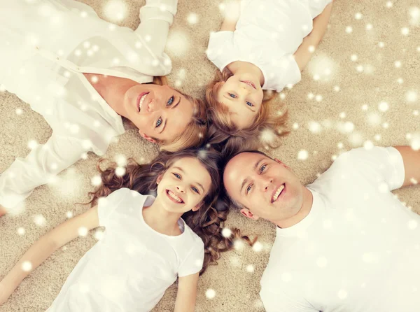 Parents and two girls lying on floor at home — Stock Photo, Image