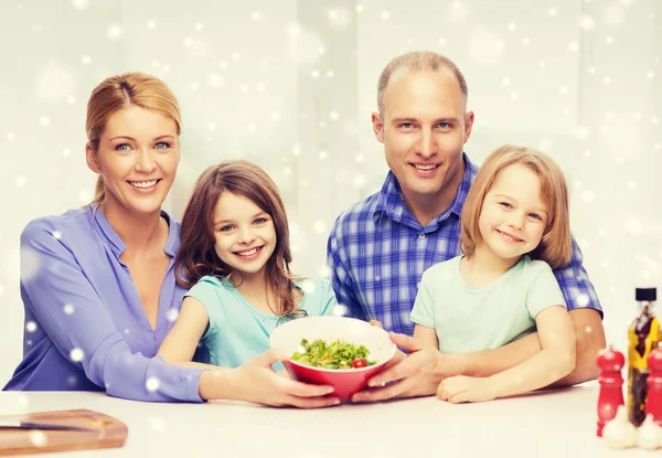 Счастливая семья с двумя детьми, показывающая салат в миске — стоковое фото