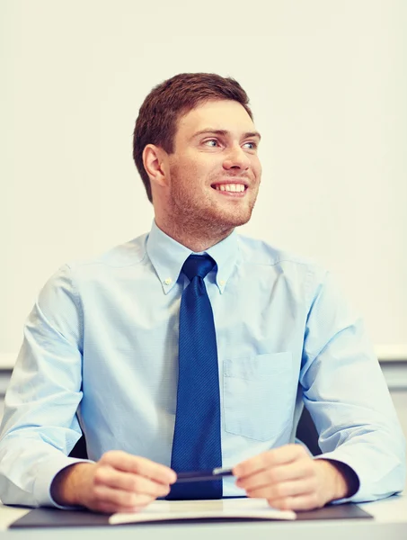 Uśmiechający się biznesmen siedzi w biurze — Zdjęcie stockowe