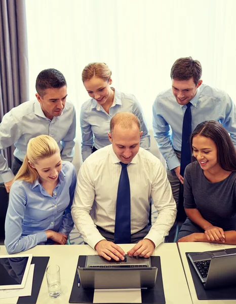 Gente d'affari sorridente con computer portatile in ufficio — Foto Stock