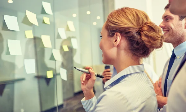 Smiling business people with marker and stickers — Stock Photo, Image