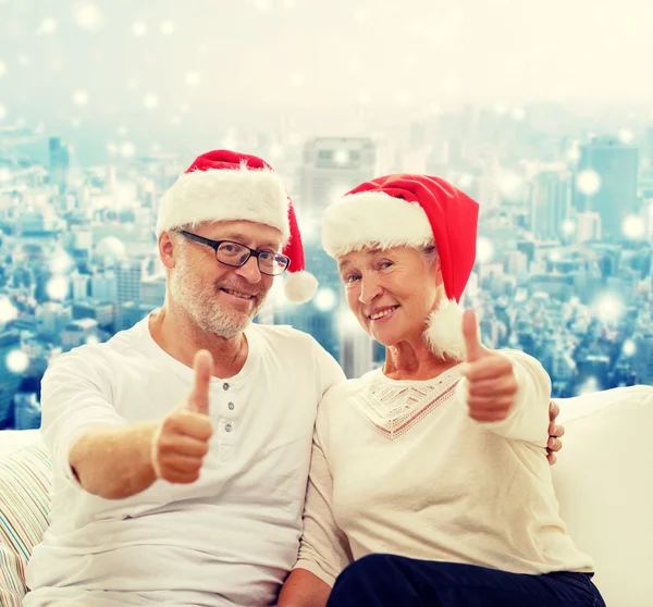 Happy senior couple in santa helper hats — Stock Photo, Image