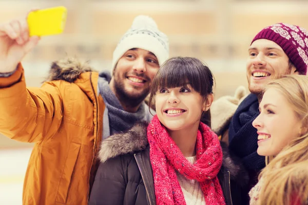 Amici felici prendendo selfie sulla pista di pattinaggio — Foto Stock