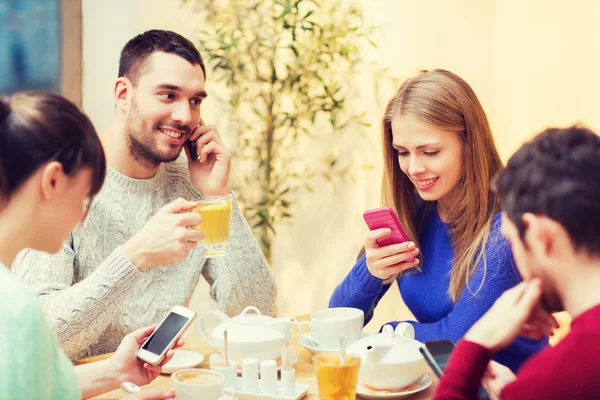 Sällskap med smartphones möte på café — Stockfoto