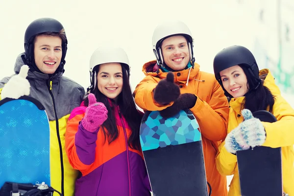 Happy friends in helmets with snowboards — Stock Photo, Image