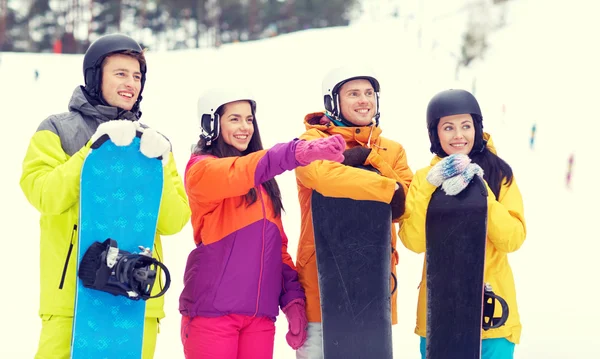 Amigos felices en cascos con snowboards —  Fotos de Stock