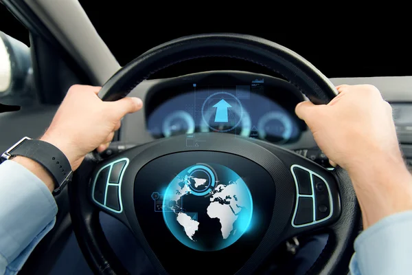 Close up of man driving car with globe on screen — ストック写真
