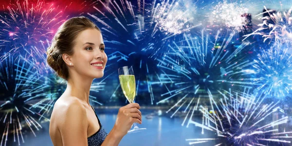 Glückliche Frau trinkt Champagner über Feuerwerk — Stockfoto