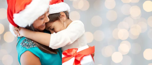 Happy mother and little girl in santa hats — Stock Photo, Image