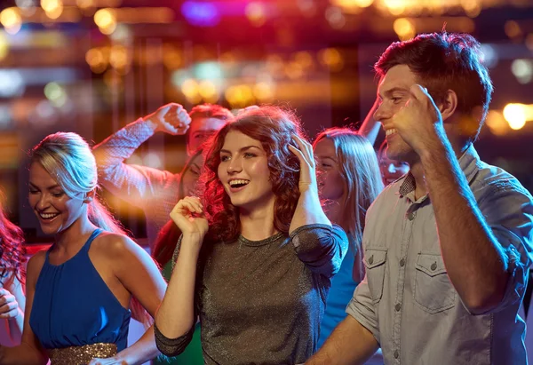 Grupo de amigos felizes dançando no clube noturno — Fotografia de Stock