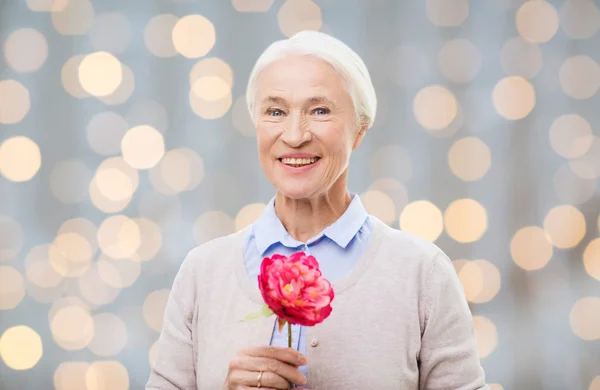 Tersenyum bahagia wanita senior dengan bunga di rumah — Stok Foto