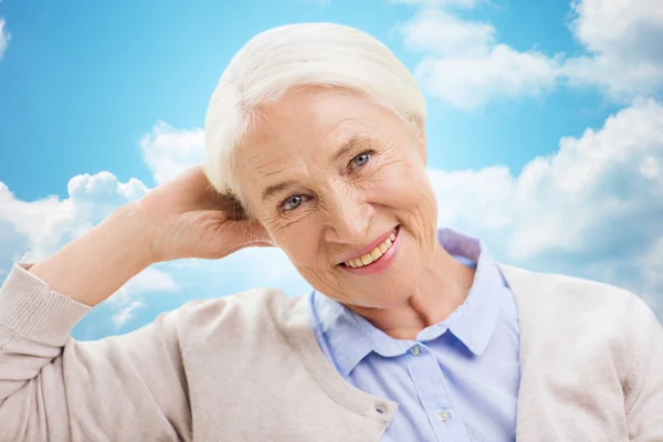 Happy senior woman over blue sky and clouds — Φωτογραφία Αρχείου