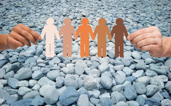Hands holding people pictogram over stone desert — Stock Photo, Image