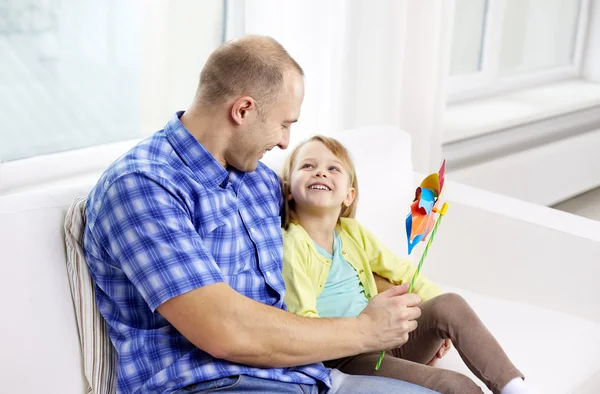 Happy father and daughter sitting on sofa at home — Stock Photo, Image