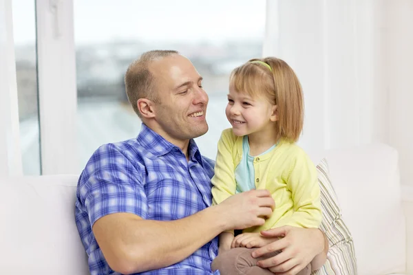 Happy father and daughter sitting on sofa at home — Stock Photo, Image