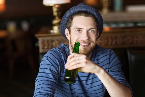Gelukkig jonge man drinken bier bij bar of pub — Stockfoto