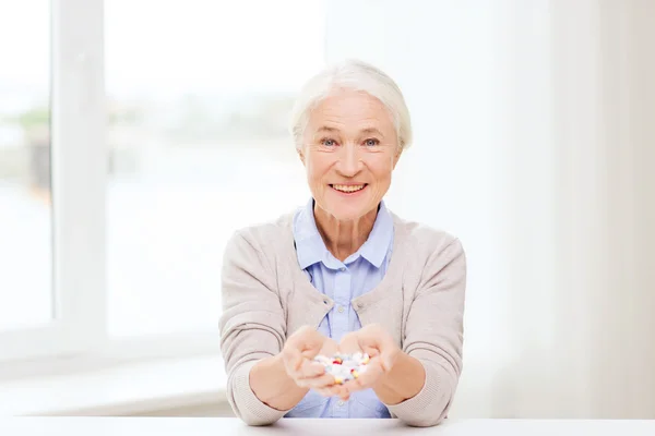Feliz mujer mayor con la medicina en casa — Foto de Stock