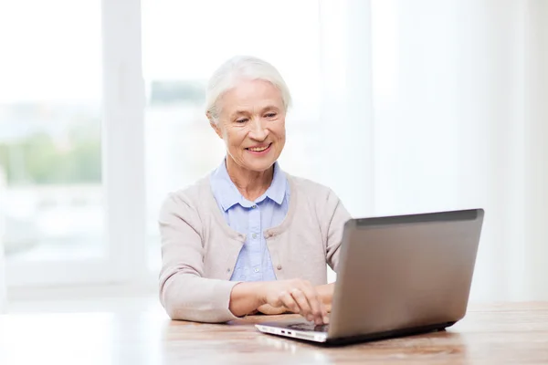 Mulher sênior feliz com laptop em casa — Fotografia de Stock