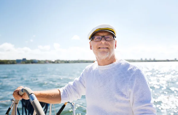 Старший чоловік на шоломі на човні або яхті, що пливе в морі — стокове фото