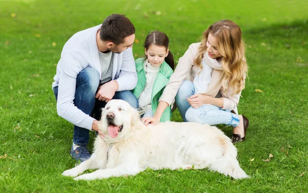 公園でラブラドールレトリバー犬と幸せな家族 — ストック写真