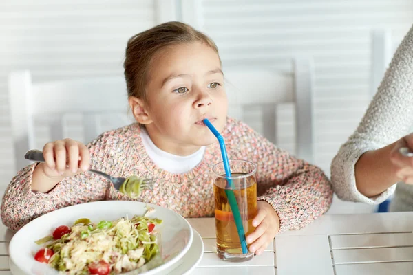 Lilla flickan dricker äppeljuice på restaurang — Stockfoto
