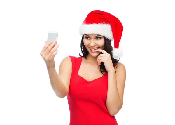 Woman in santa hat taking selfie by smartphone — Stock Photo, Image