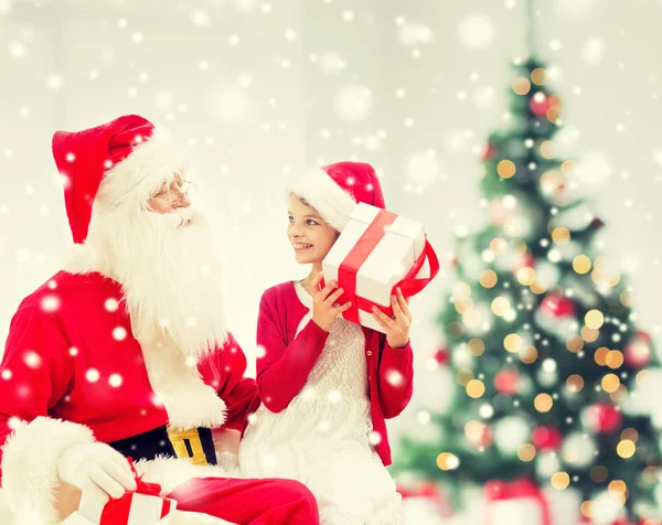 Sorrindo menina com Papai Noel e presentes Imagem De Stock