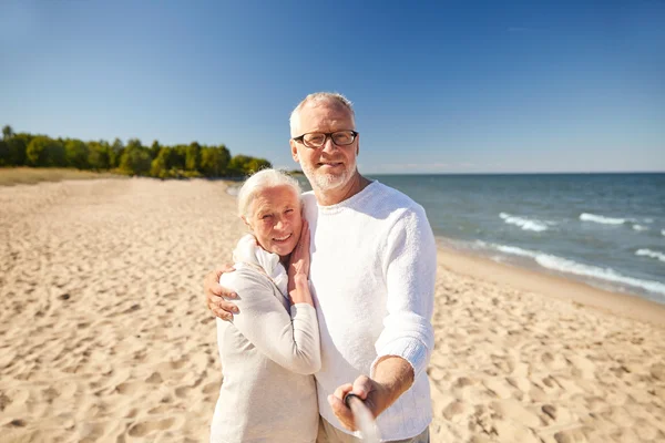 Senioren fotografieren mit Selfie-Stick am Strand Stockfoto
