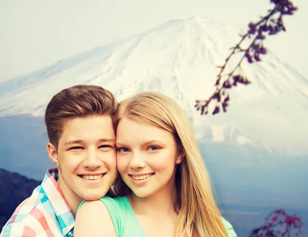 Sorrindo casal abraçando sobre montanhas fundo — Fotografia de Stock