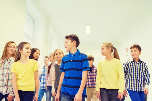 Grupo de niños sonrientes de la escuela caminando en el pasillo — Foto de Stock