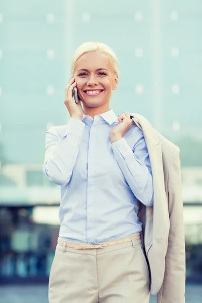 Glimlachende zakenvrouw met smartphone outdoors — Stockfoto