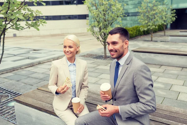 Hombres de negocios sonrientes con vasos de papel al aire libre — Foto de Stock