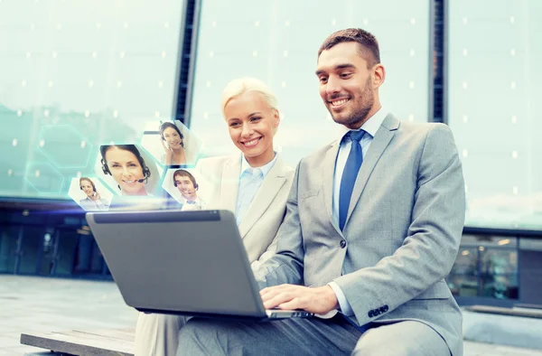 Sonrientes empresarios con portátil al aire libre — Foto de Stock