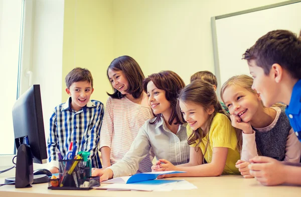 Grupa dzieci z nauczycielem i komputer w szkole — Zdjęcie stockowe