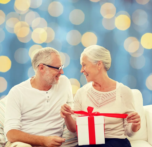 Heureux couple aîné avec boîte cadeau — Photo