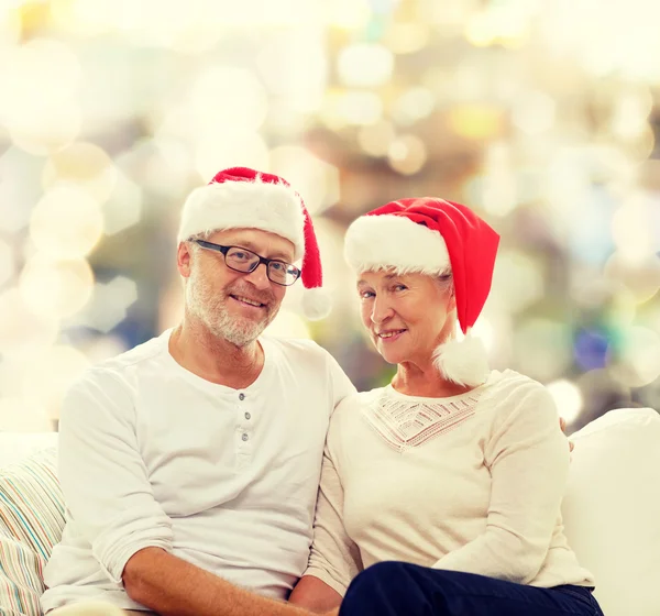 Šťastný starší pár v santa pomocníka klobouky — Stock fotografie