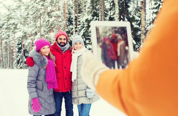 Smiling friends with tablet pc in winter forest — Stock Photo, Image