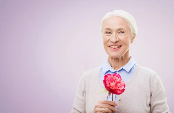 Feliz sorrindo mulher sênior com flor — Fotografia de Stock