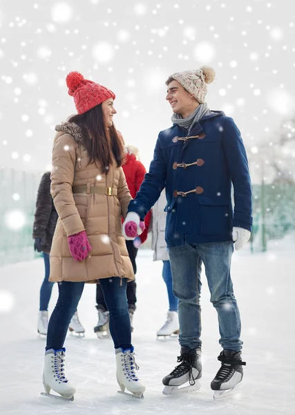 Happy friends ice skating on rink outdoors — Stock Photo, Image