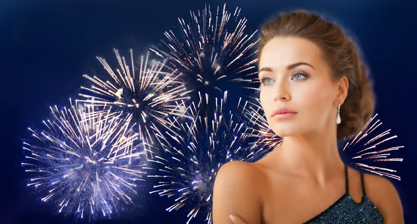 Hermosa mujer con pendientes sobre fuegos artificiales — Foto de Stock