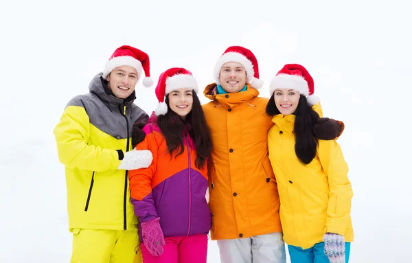 Glückliche Freunde in Weihnachtsmützen und Skianzügen im Freien — Stockfoto